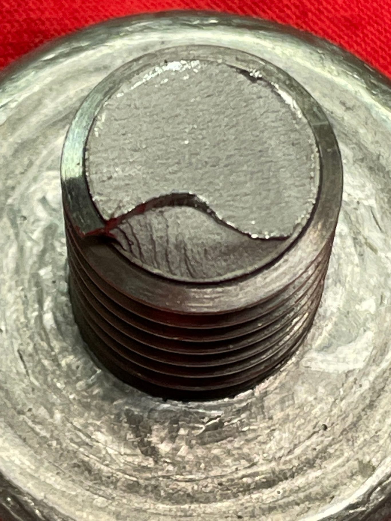 Fully threaded bolt failed in low cycle fatigue due to pre-existing cracks. Material: Steel